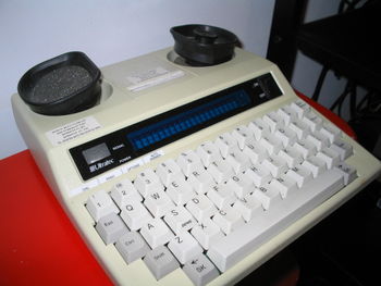 Miniprint 425 TDD. The coupler on the top is for use with telephone handsets. The printer records the conversation. The specific GA & SK keys allow for speedier use of common abbreviations.